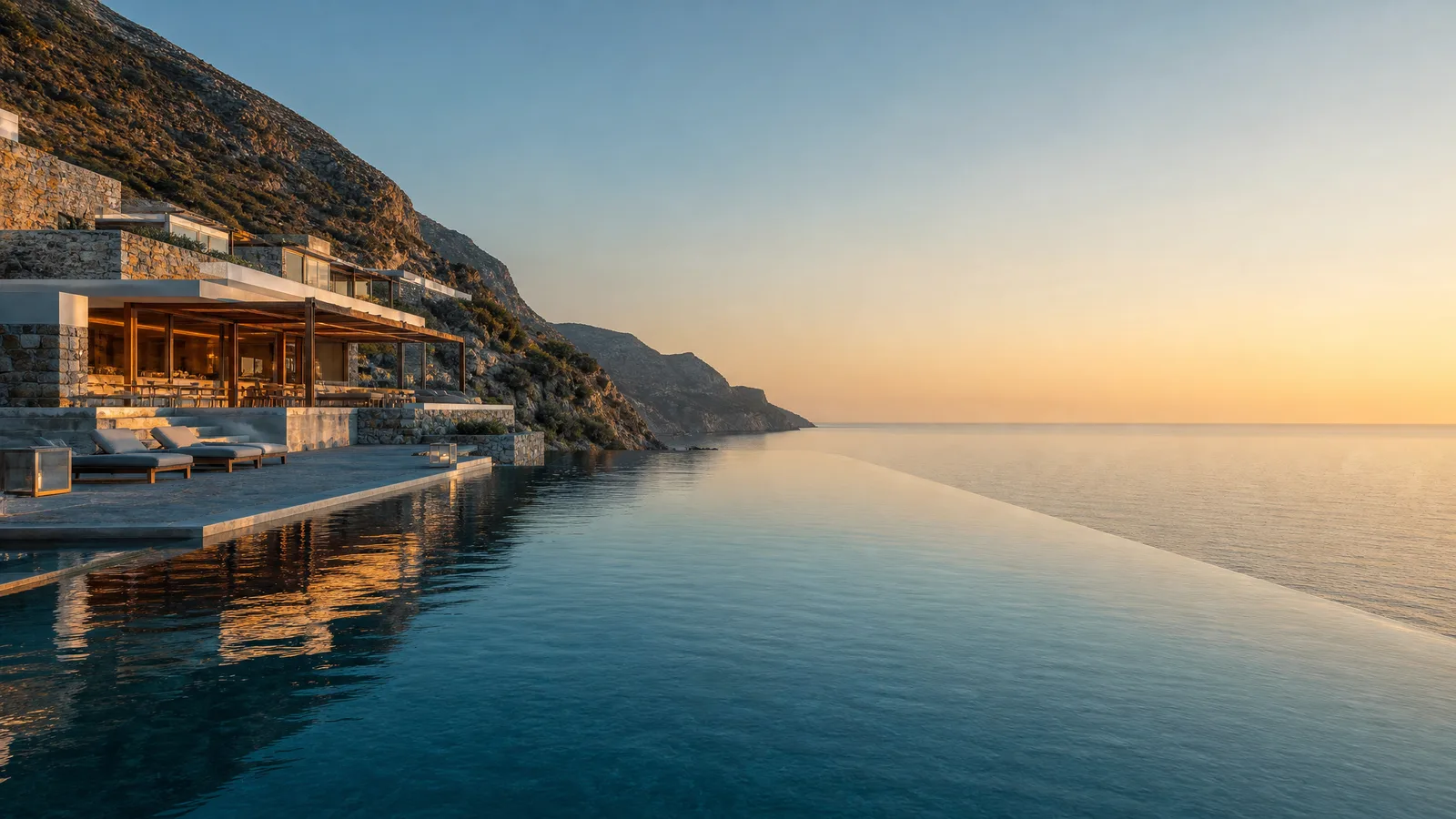A clifftop resort at golden hour, its infinity pool meeting the ocean horizon